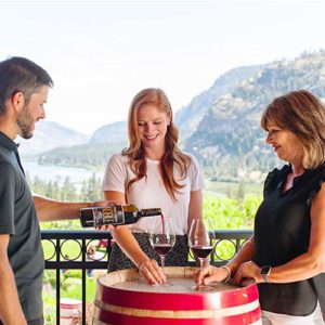 Waiter pouring wine for two female guests outdoors at Noble Ridge